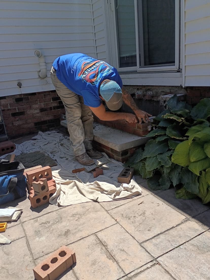 Worker rebuilding brick steps